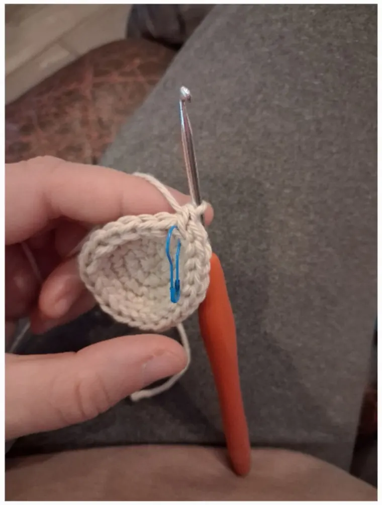 The first single crochet worked into a magic ring, with a stitch marker